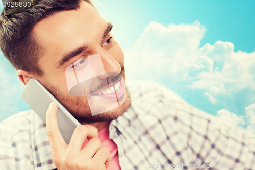 Image of smiling young man calling on smartphone