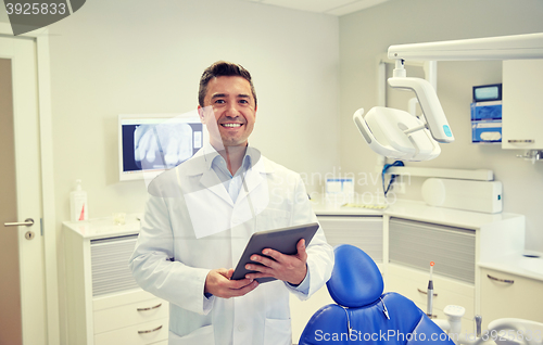 Image of happy male dentist with tablet pc at dental clinic