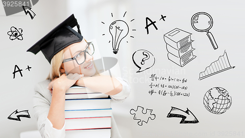 Image of happy student woman in mortarboard with books