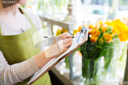 Image of close up of woman with clipboard at flower shop