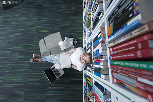 Image of female student study in library, using tablet and searching for 