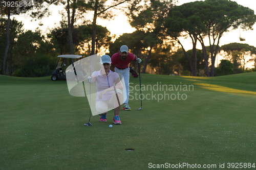 Image of couple on golf course at sunset