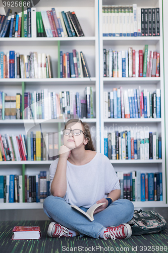 Image of famale student reading book in library