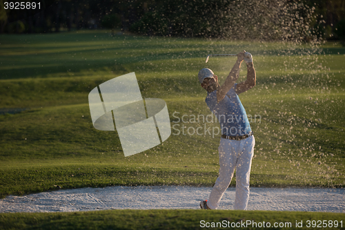 Image of golfer hitting a sand bunker shot on sunset