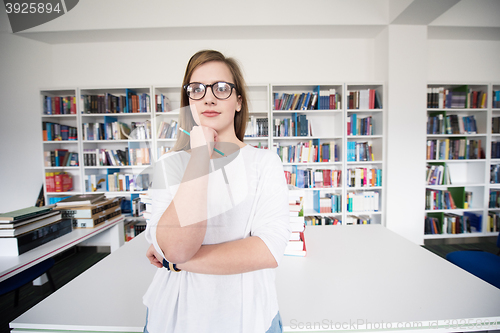 Image of female student study in library, using tablet and searching for 