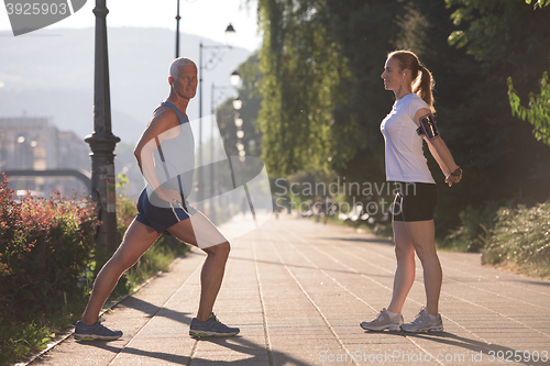 Image of couple warming up and stretching before jogging