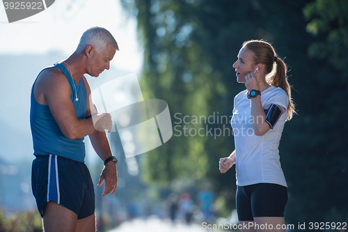 Image of jogging couple planning running route  and setting music