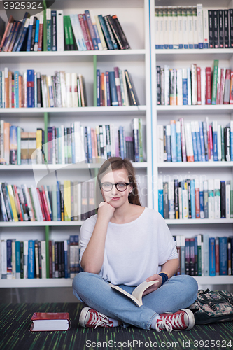 Image of famale student reading book in library