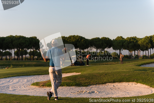 Image of golfer from back at course looking to hole in distance