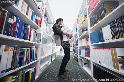 Image of Student holding lot of books in school library