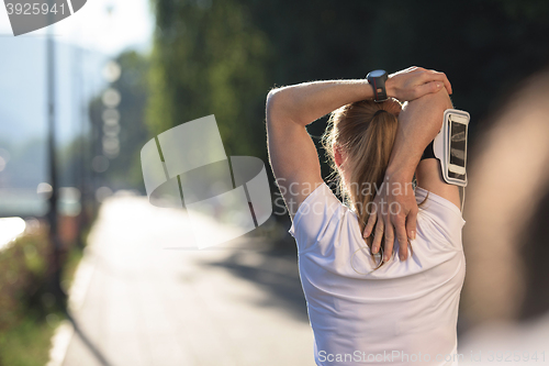 Image of blonde woman  stretching before morning jogging