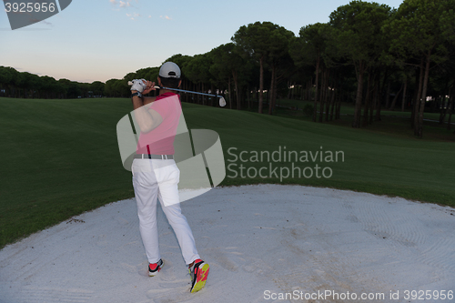 Image of golfer hitting a sand bunker shot on sunset