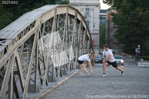 Image of couple warming up and stretching before jogging