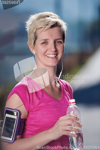 Image of woman drinking  water after  jogging