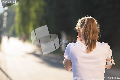 Image of jogging woman setting phone before jogging