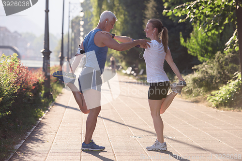 Image of couple warming up and stretching before jogging