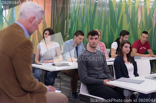 Image of teacher with a group of students in classroom