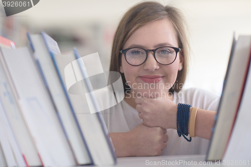 Image of portrait of famale student selecting book to read in library