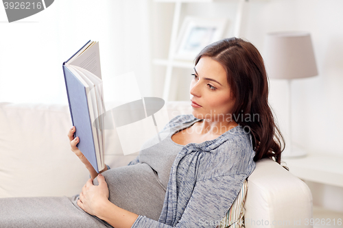 Image of pregnant woman reading book at home