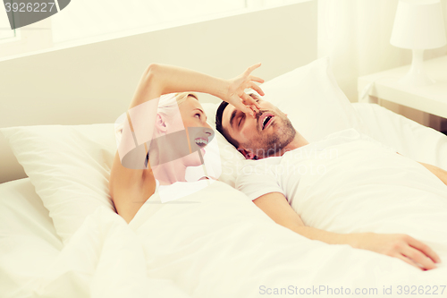 Image of happy couple sleeping in bed at home