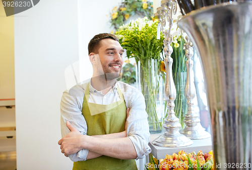 Image of happy smiling florist man standing at flower shop