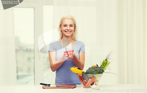 Image of smiling young woman cooking vegetables at home