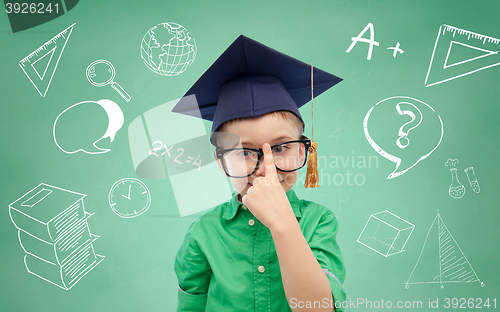 Image of boy in bachelor hat and eyeglasses over blackboard