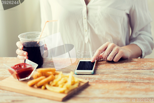Image of close up of woman with smart phone and fast food