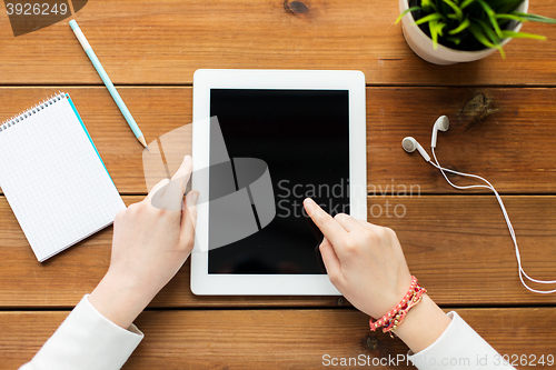 Image of close up of woman with tablet pc on wooden table