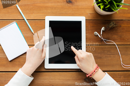 Image of close up of woman with tablet pc on wooden table