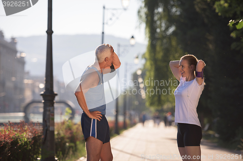 Image of jogging couple planning running route  and setting music