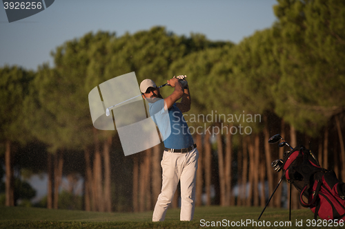 Image of golfer hitting a sand bunker shot on sunset