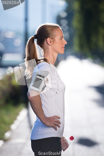 Image of woman drinking  water after  jogging