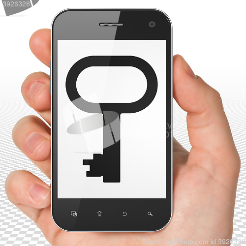 Image of Protection concept: Hand Holding Smartphone with Key on display