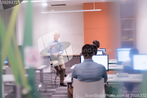 Image of teacher and students in computer lab classroom