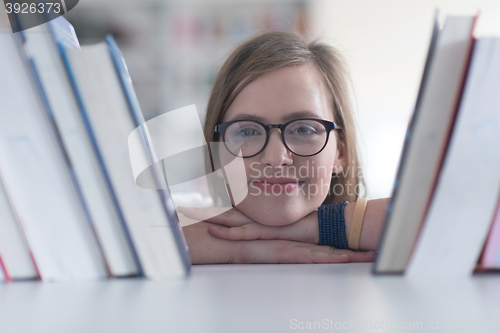 Image of portrait of famale student selecting book to read in library