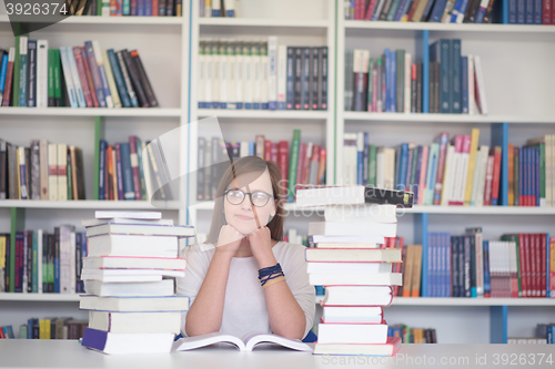 Image of female student study in library, using tablet and searching for 