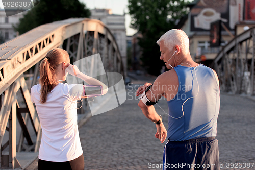 Image of jogging couple planning running route  and setting music