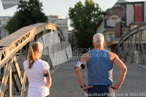 Image of jogging couple planning running route  and setting music