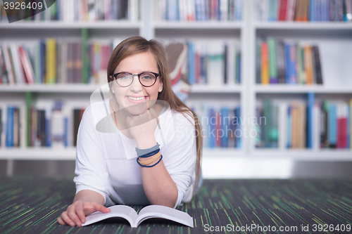 Image of female student study in library, using tablet and searching for 