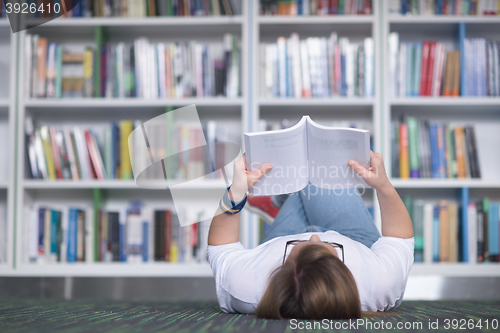 Image of female student study in library, using tablet and searching for 