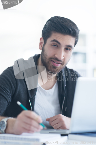 Image of student in school library using laptop for research