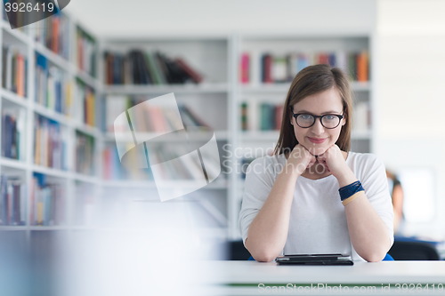 Image of female student study in school library, using tablet