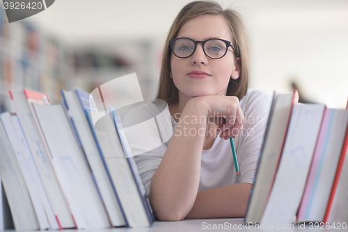 Image of portrait of famale student selecting book to read in library