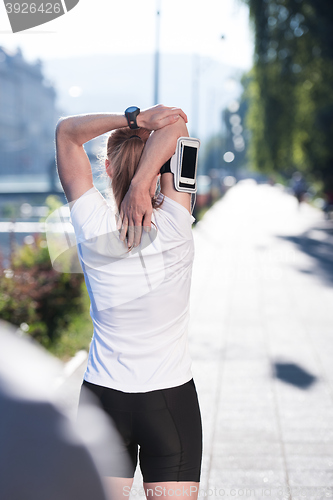 Image of blonde woman  stretching before morning jogging