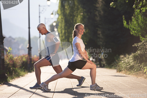 Image of couple warming up and stretching before jogging