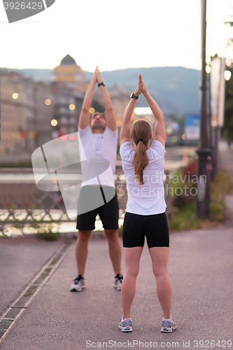 Image of couple warming up before jogging