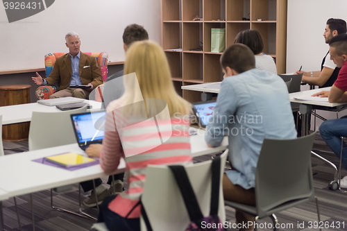 Image of teacher with a group of students in classroom