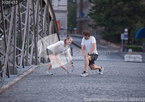 Image of couple warming up and stretching before jogging