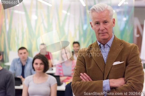 Image of portrait of  teacher with students group in background